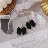 Elegant black bowknot earrings adorned with baguette-cut cubic zirconia crystals, perfect for any occasion.